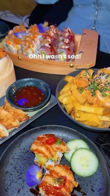 Sushiboot, friet met topping, gyoza en sushi met komkommer op tafel