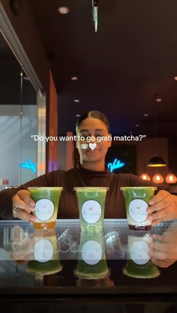 Medewerker zet drie bekers matcha met het La Vida-logo op de toonbank